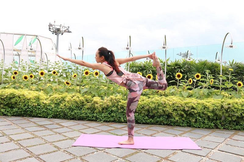 A lady doing yoga at the Sunflower Garden.