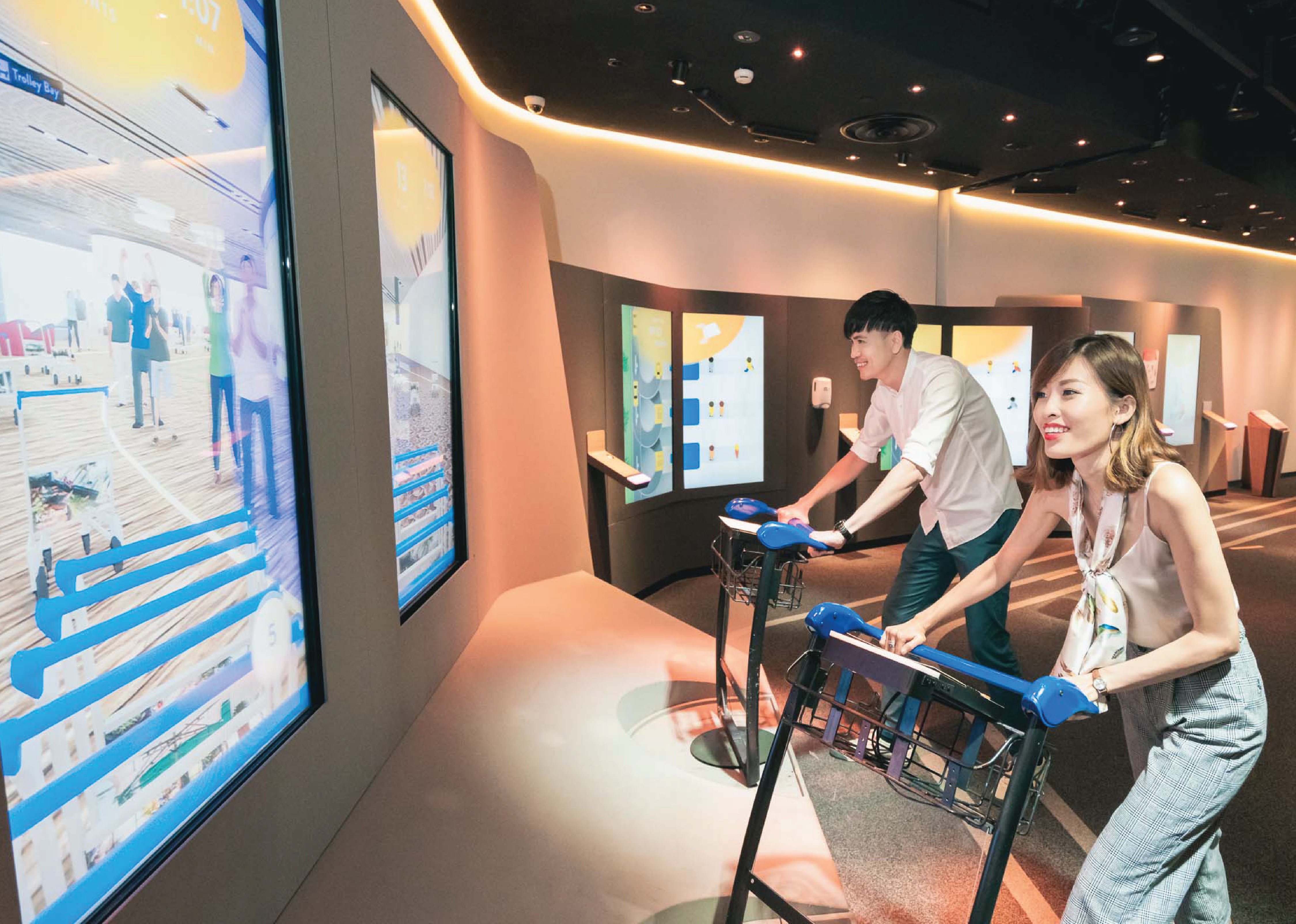 couple navigating airport trolleys through a game at changi airport in singapore