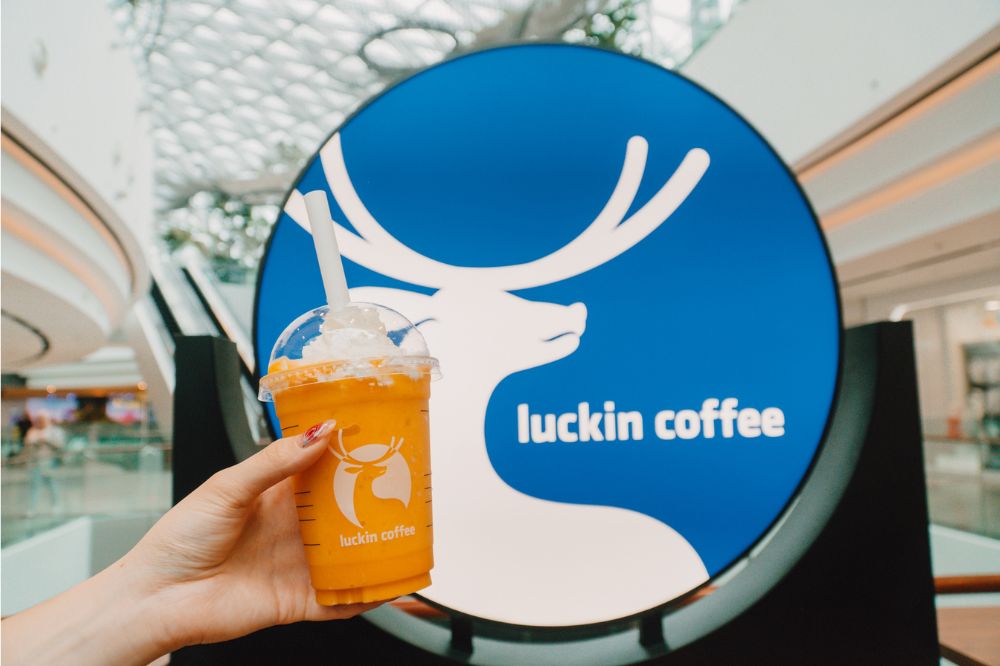 luckin coffee jewel's mango exfreezo drink in front of its physical shop logo, changi airport singapore