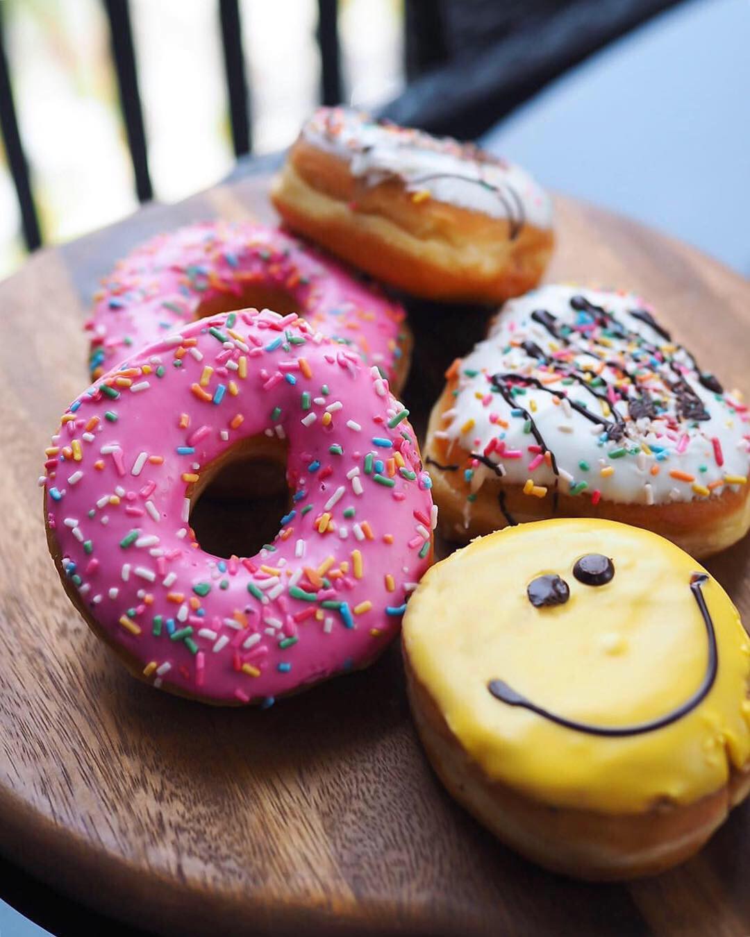 A plate of colourful, delicious looking donuts.
