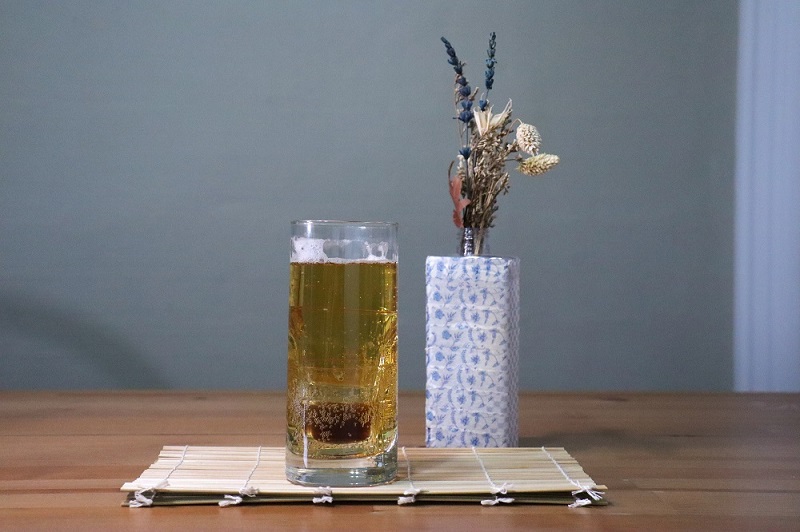 A glass of Cojinganmek cocktail displayed on a table.