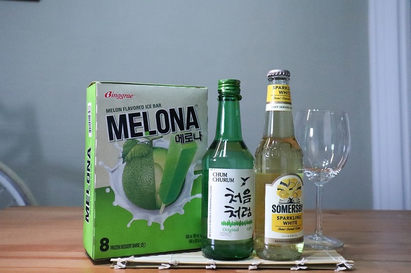 A pack of Melona ice cream, origina soju, chilsung cider and cocktail glass displayed on a table.