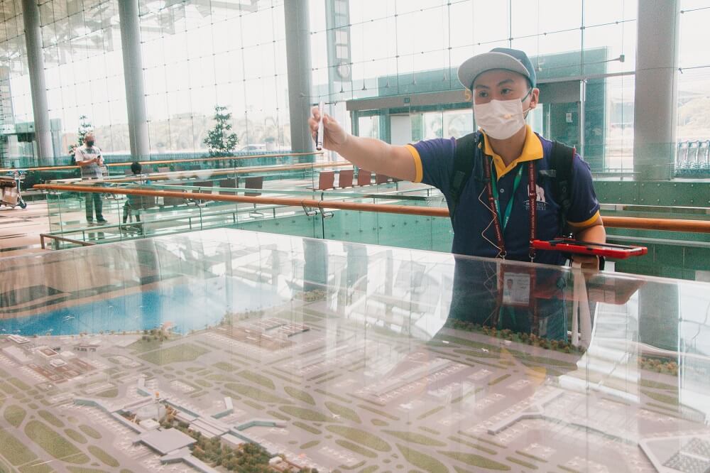Tour guide explaining the development of the Changi at the airport model in Terminal 3