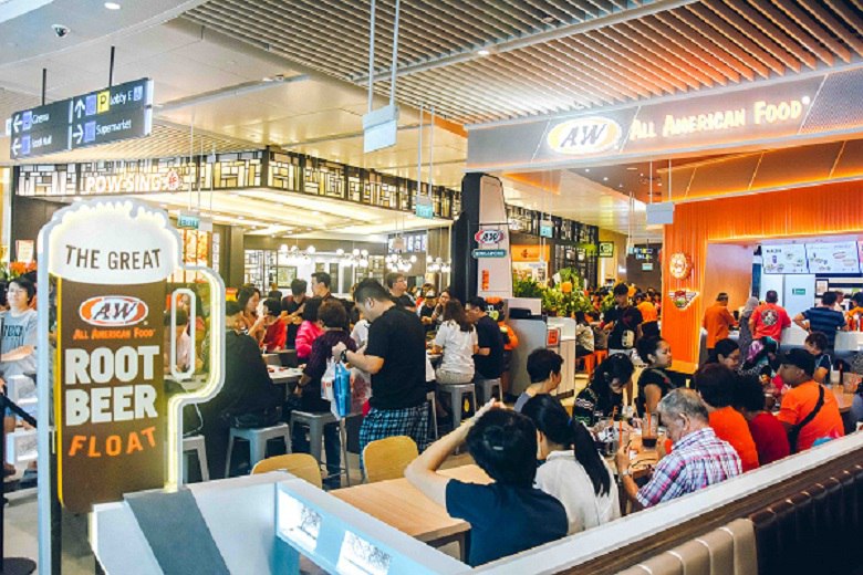 Frontal view of A&W shop façade with hordes of people queuing and eating