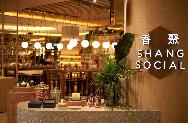 Frontal view of Shang Social with restaurant name in the foreground and a peek into the interior in the background