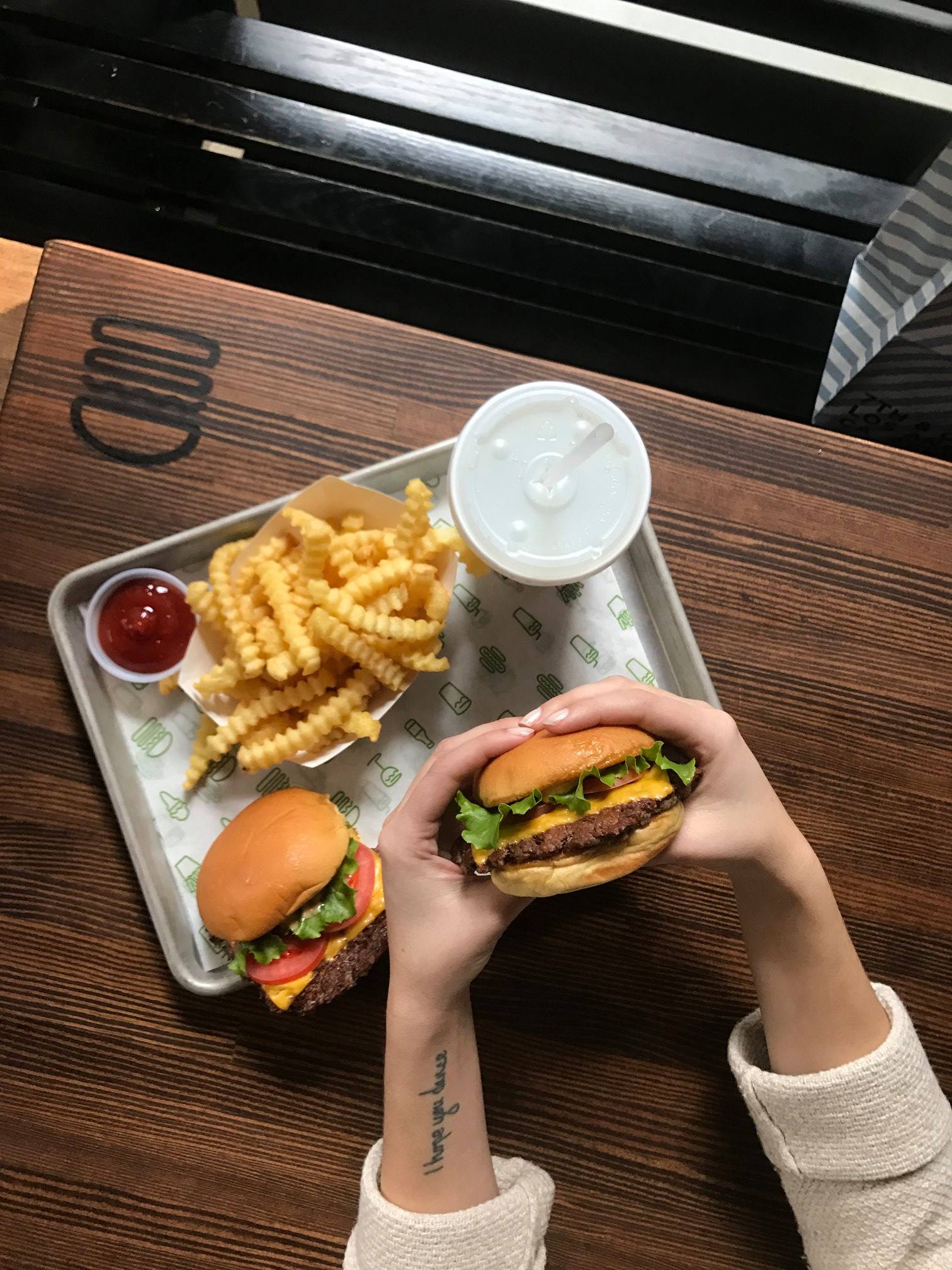 Flat-lay picture of a complete meal of Shack Shack comprising fries, drink and burger