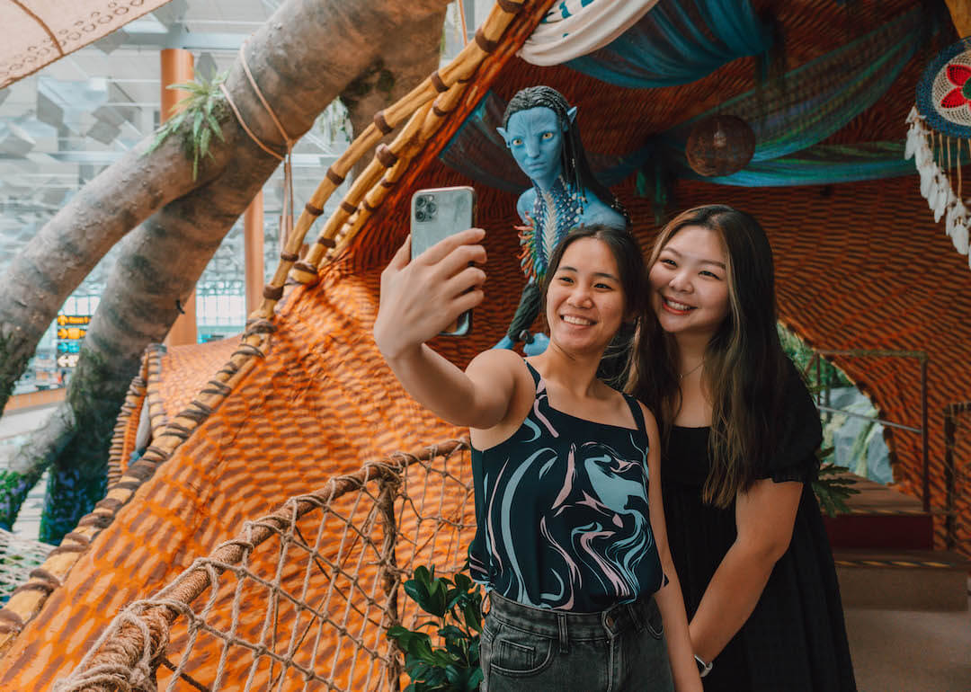 visitors taking selfie at t3 marui pod, changi festival village, singapore airport