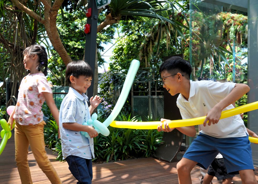 kids playing sword fighting with balloon sculpture at birthday party venue in canopy park jewel changi airport singapore