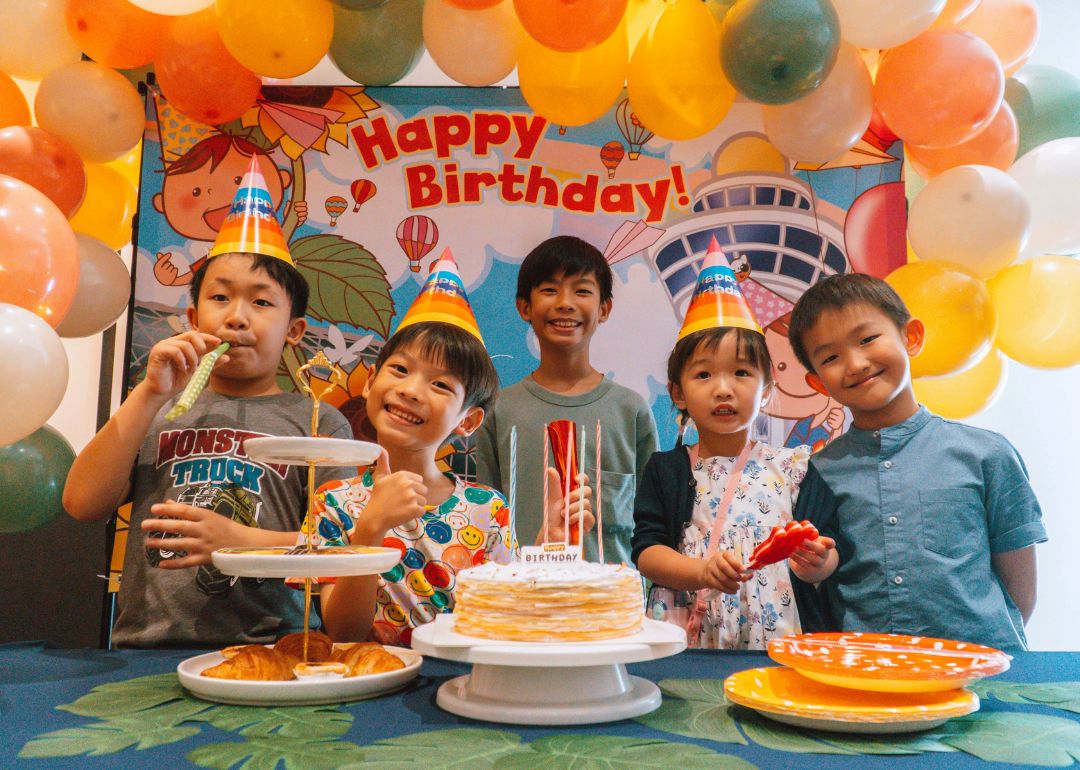 kids posing at a birthday party at changi experience studio venue against balloon decorations and backdrop