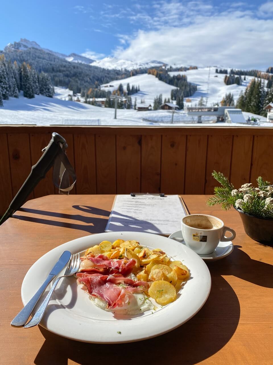 ham, eggs and fried potatoes for lunch in italy against snow backdrop
