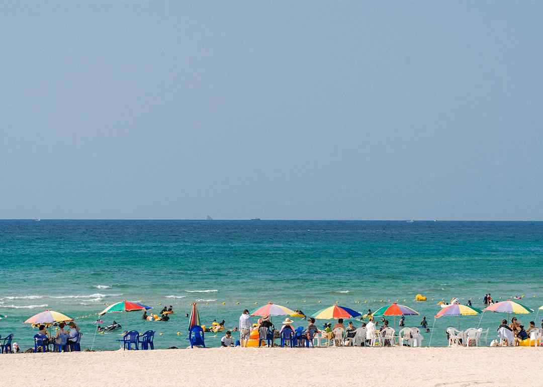 tourists and locals relaxing at gwakji beach on jeju island, south korea