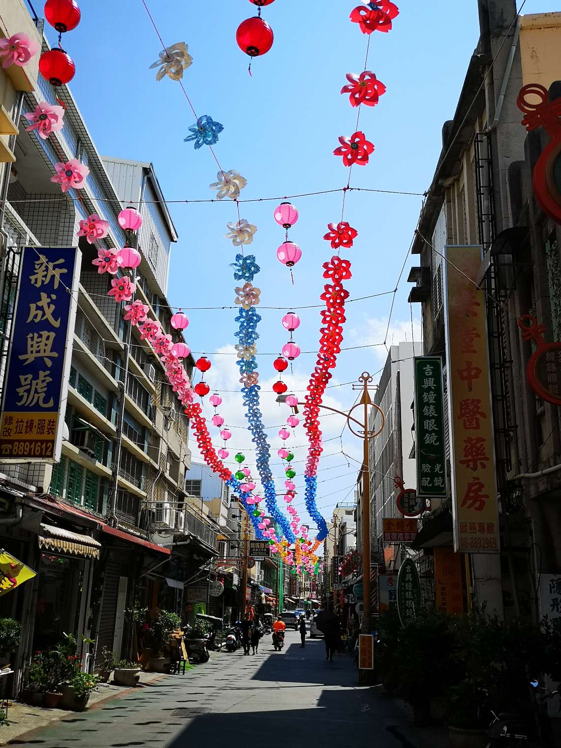 Paper pinwheels strung above the streets in Heng Chun old town
