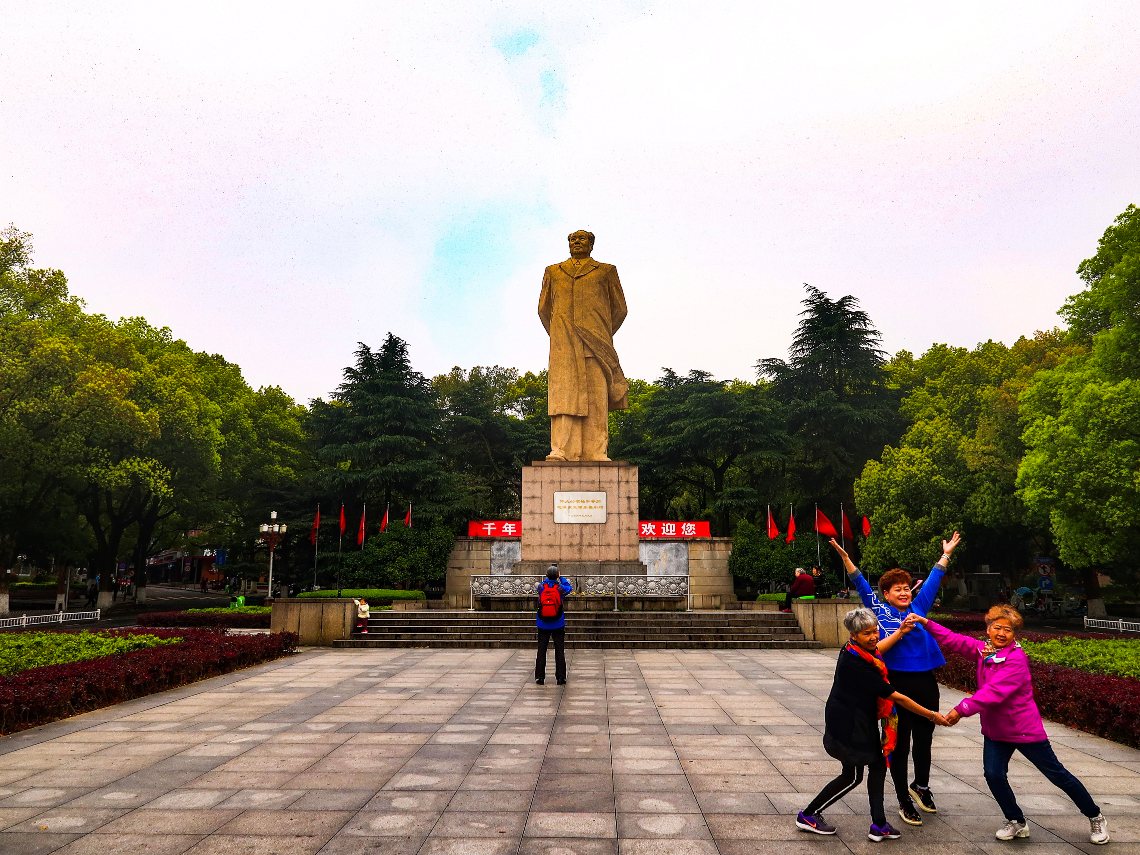 Creative poses by locals in front of statue of Mao Zedong at Hunan University, Changsha