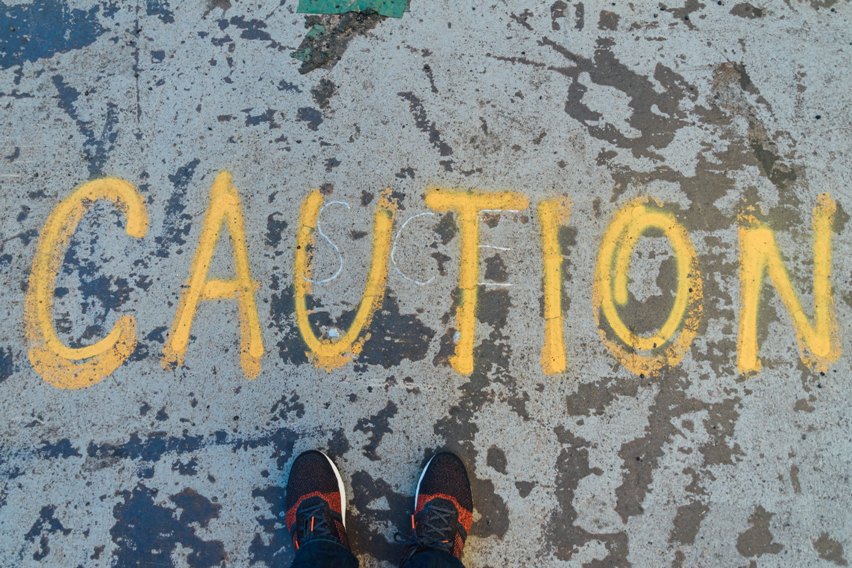 'Caution' written on a concrete floor