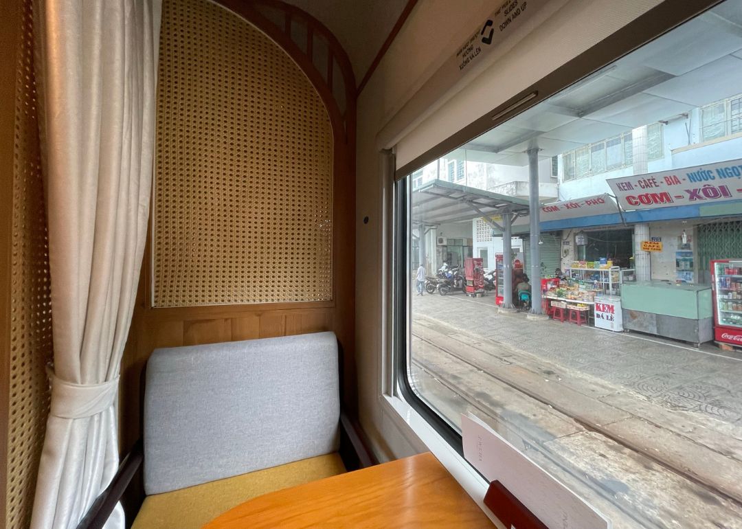 View of a booth seat and train station vendors outside the windows.