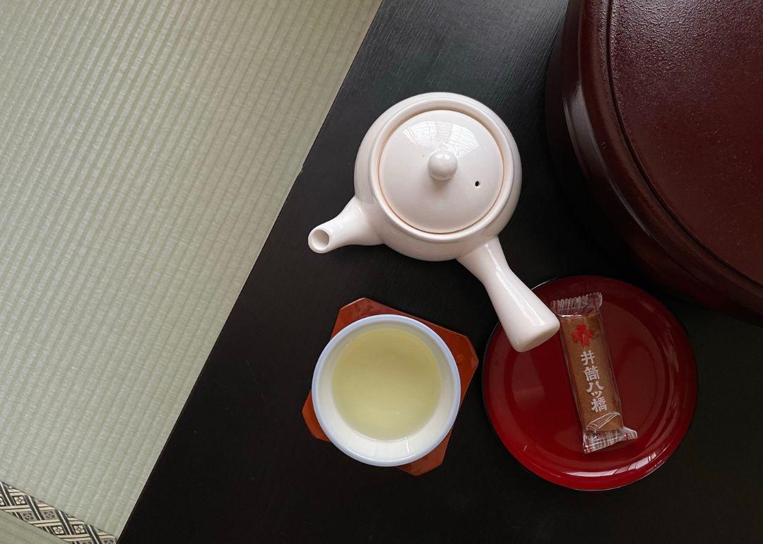 overhead shot of a teapot tea cup and snacks served at hirashin ryokan in kyoto