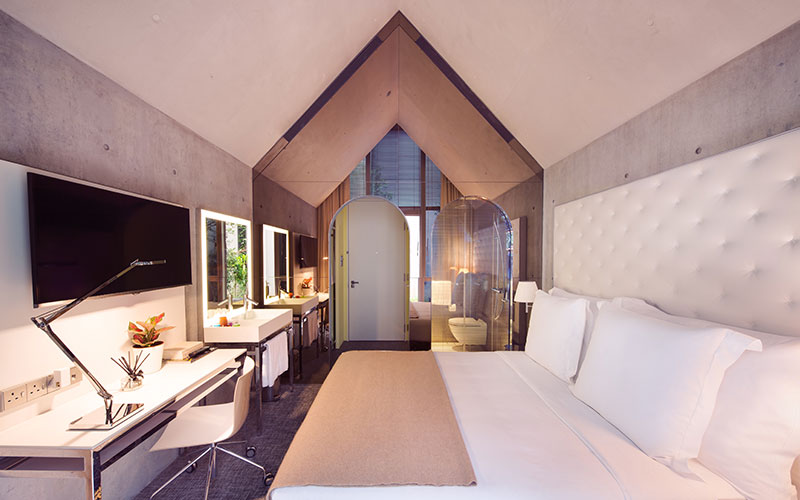 A chapel-like pitched ceiling makes for a spacious room at M Social Singapore.