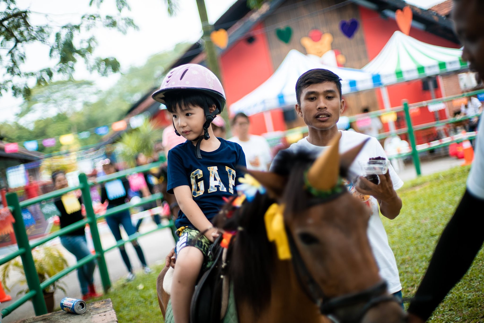 a young boy rides a horse at gallop stable at north west singapore