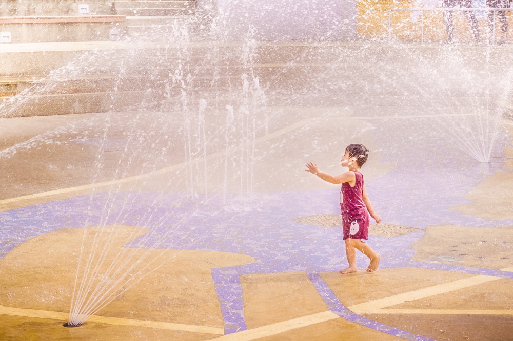 a little girl playing in a water park at lower seletar reservoir park, singapore