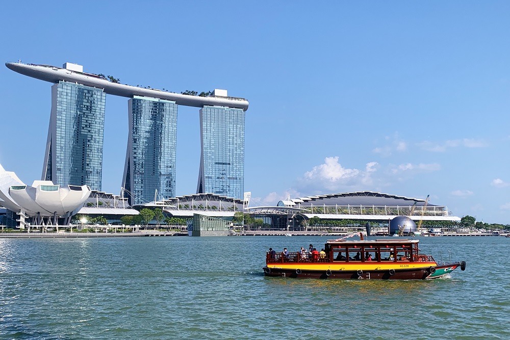 scenic view of marina bay sands singapore with river cruise boat passing by