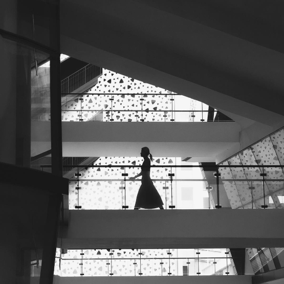 Silhouette of woman crossing the bridge at LASALLE College of the Arts