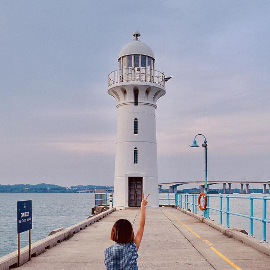 Woman in front of the Raffles Marina Lighthouse