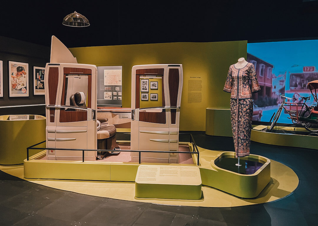 a suites seat cabin is on display with a singapore airline stewardess uniform at national museum singapore