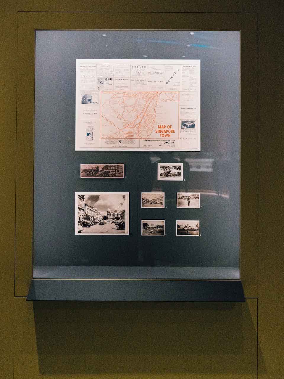 a tourist map and old photos of singapore on display at the travel exhibition located in national museum singapore