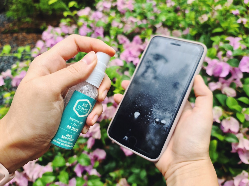 sdtravel spray being used on a mobile phone